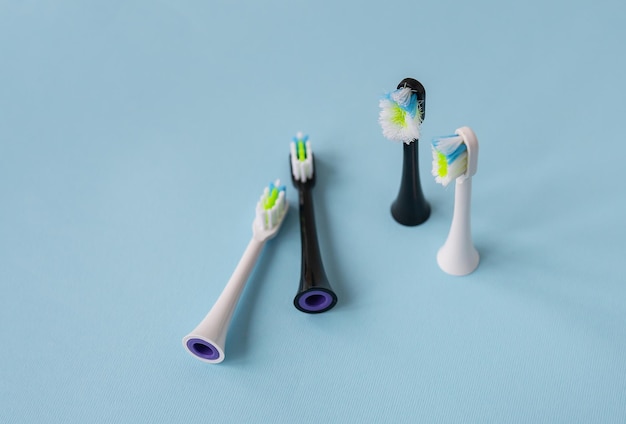 Modern electric toothbrush standing on a blue background time to change the brushold and new brush head A controlled product for daily care of the oral cavity Hygiene concept