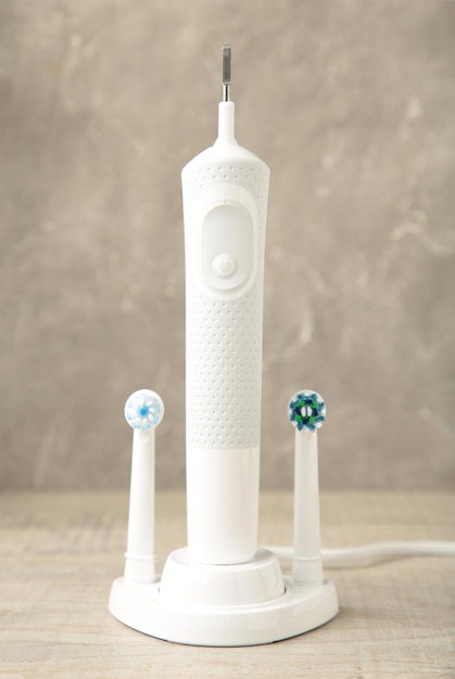 Modern electric toothbrush with charger on grey background