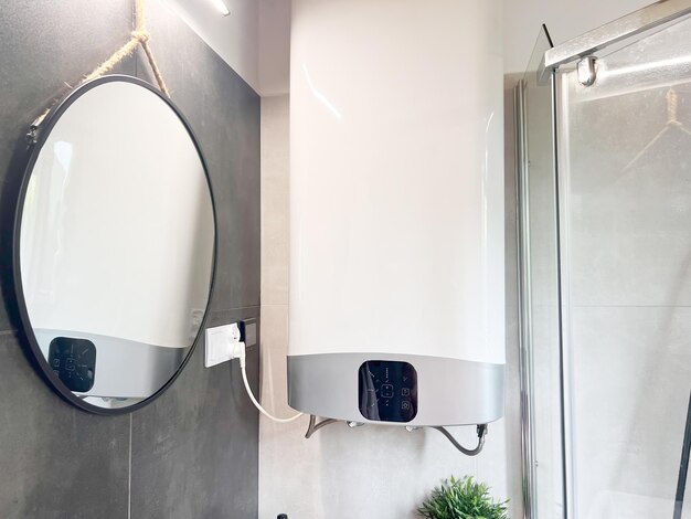 Photo modern electric water heater installed in home bathroom