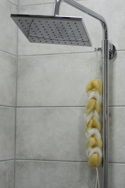 Modern elegant stainless steel shower head and washcloths hanging. Copy space