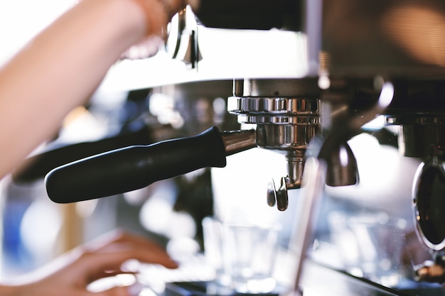 A modern expensive coffee machine is shown in work in modern cozy coffee shop. .