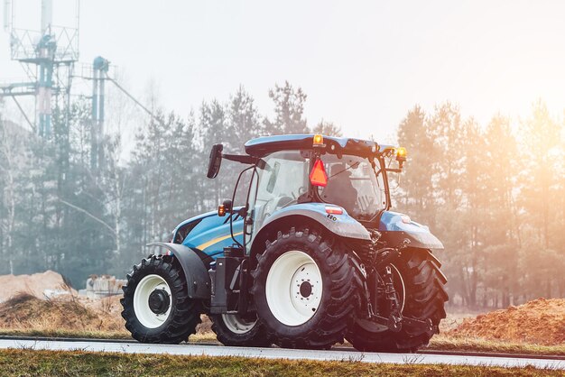 modern farmer tractor on rural road foggy morning