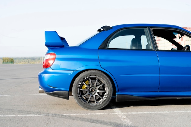 A modern fast race sport blue car  on the track on summer practice day