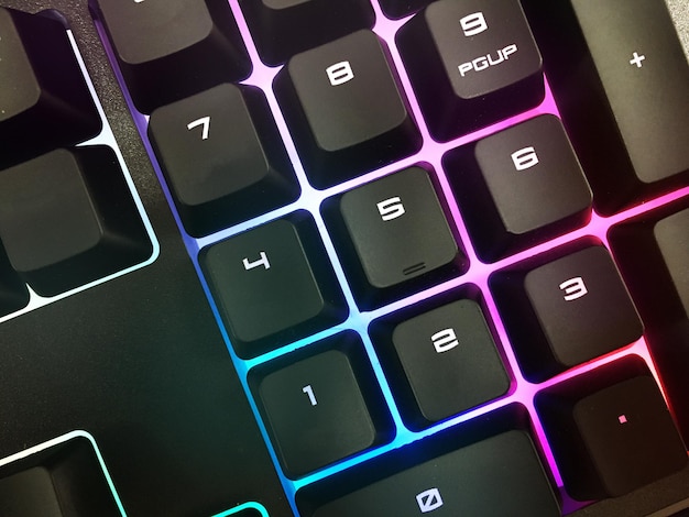 Modern gaming keyboard with bright backlit keys on the table