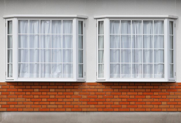 Modern glass window with brick block on cement facade wall background.