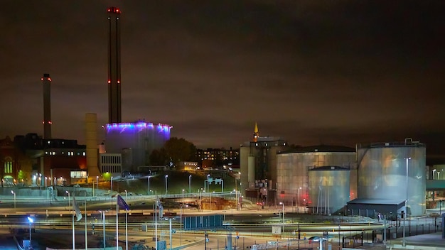 Modern grain terminal at night Metal tanks of elevator Graindrying complex construction Commercial grain or seed silos at seaport Steel storage for agricultural harvest