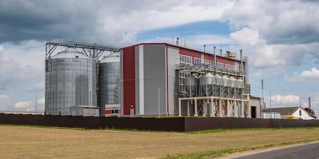 Modern Granary elevator and seed cleaning line Silver silos on agroprocessing and manufacturing plant for processing drying cleaning and storage of agricultural products flour cereals and grain