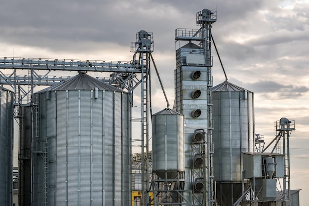 Modern Granary elevator and seed cleaning line Silver silos on agroprocessing and manufacturing plant for storage and processing drying cleaning of agricultural products flour cereals and grain