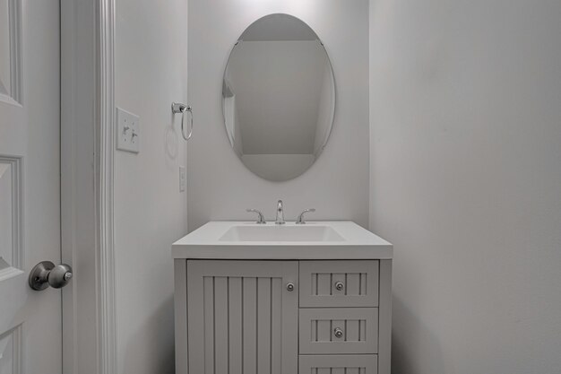 Modern Half Bathroom with Sink and Oval Mirror