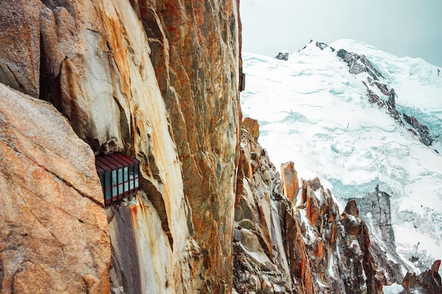 Modern house in rock of Mont Blanc mountains snowy pass in Alps peak Aiguille du Midi France