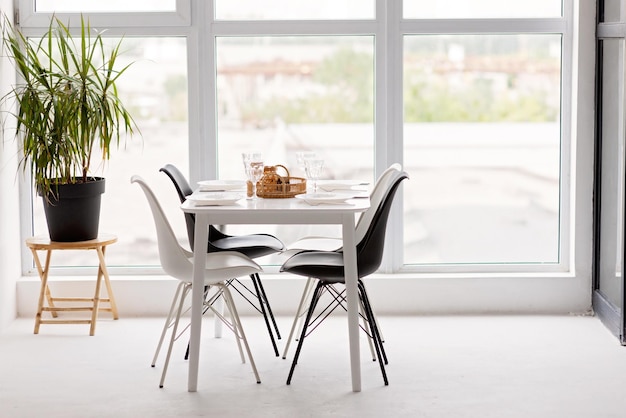 Modern interior of a cozy dining room kitchen white furniture against the background of a panoramic window Conceptual decor design house mortgage loan for a young family Soft selective focus