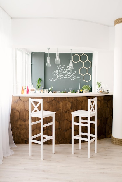 Modern interior of the living room. Wooden bar counter and white bar stools