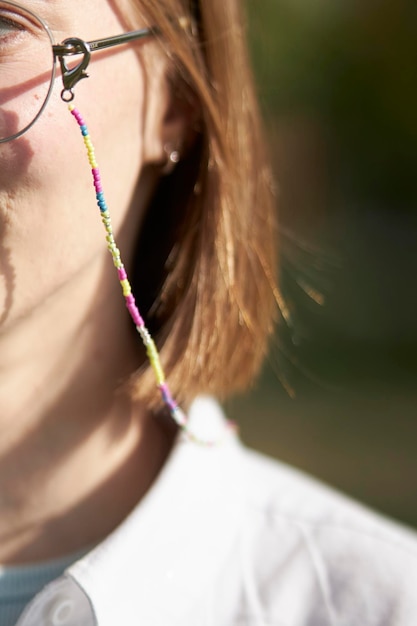 Modern jewelry made of beads and beads on the girl's glasses. Beaded chain on glasses