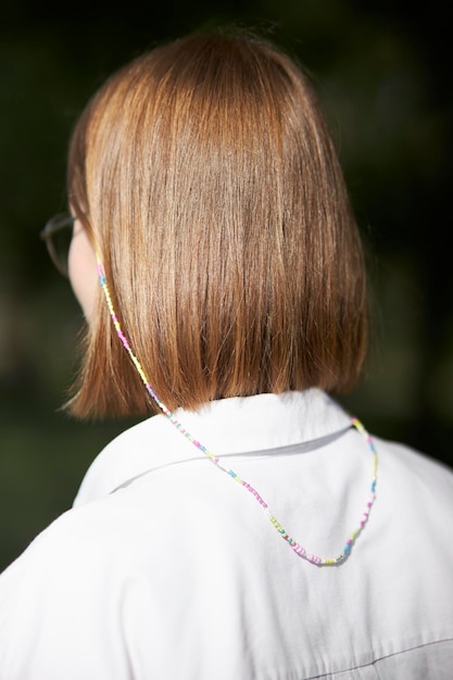 Modern jewelry made of beads and beads on the girl's glasses. Beaded chain on glasses