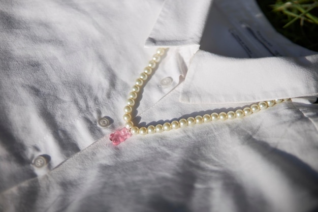 Modern jewelry made of beads and beads lies on a white shirt. beaded beads