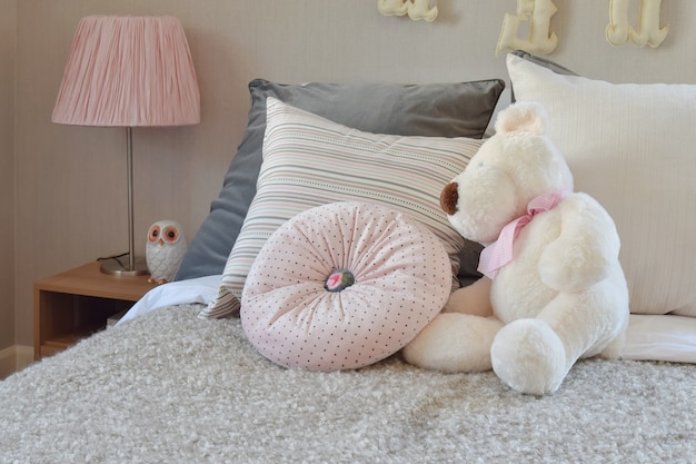 Modern kids room with doll and pillows on bed