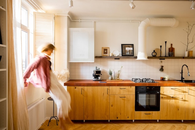 Modern kitchen interior with person sitting on window sill