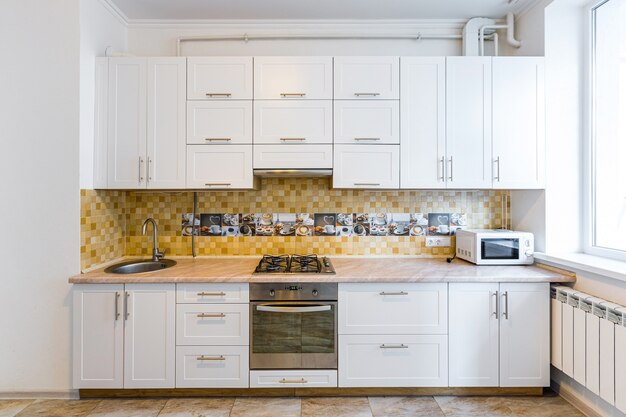  modern kitchen in light white tones with black marble tiles