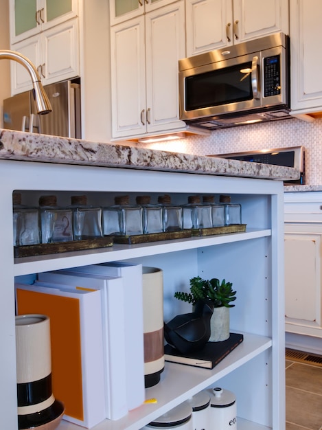 Modern kitchen with white cabinets and stainless appliances.