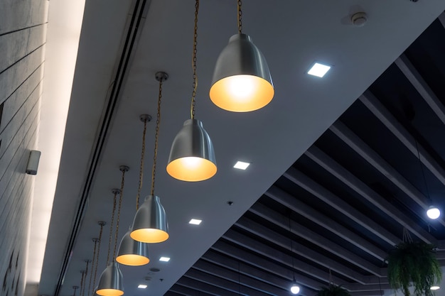 Modern lamps arrangement hanging on ceiling in restaurant