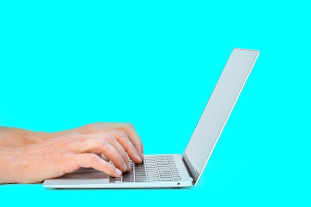 Modern laptop computer on the tabl on the blackboard background