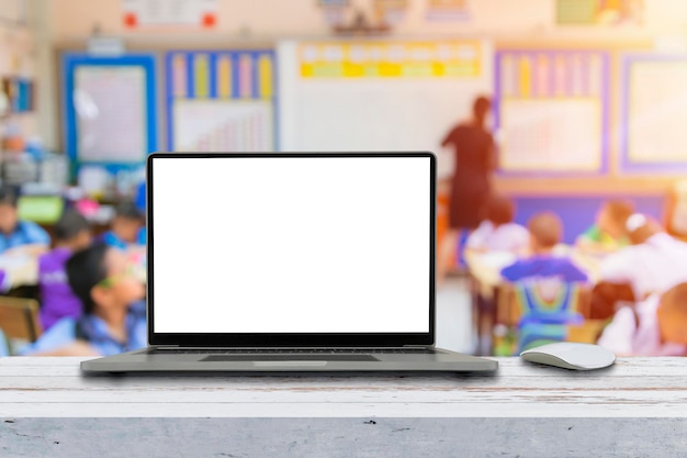 Modern laptop with blank screen on table in classroom