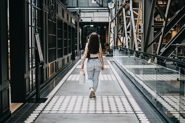 Photo modern latina young woman walking in large modern mall young pretty brunette female consumer