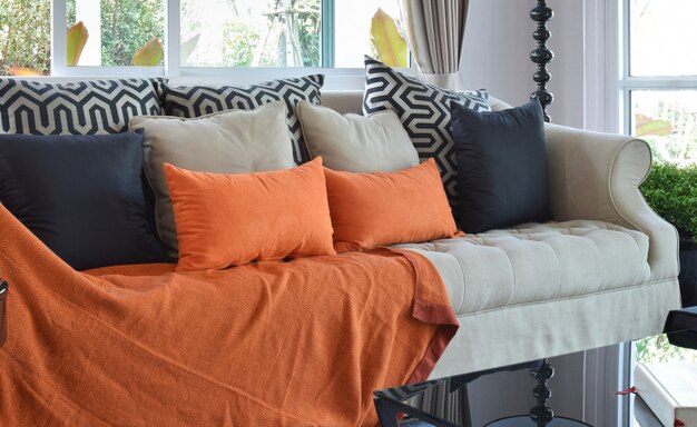 Modern living room design with brown and orange tweed sofa and black pillows