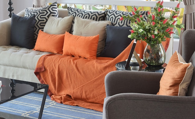 Modern living room design with brown and orange tweed sofa and black pillows