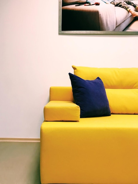 Modern living room interior with comfortable huge yellow sofa with violet pillow. Soft. Design. Stylish