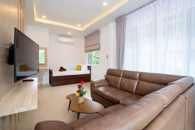 Modern living room with brown sofa, TV and day bed