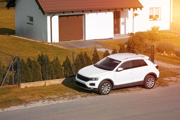 A modern and luxurious SUV car travels on an asphalt road with a breathtaking landscape of a golden sunset sky