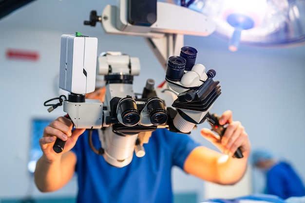 Modern microscope for operations in surgery room Group of surgeons using operating microscope during their work