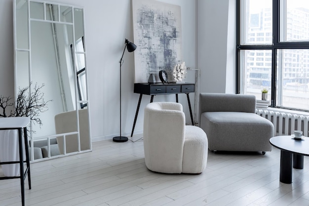 Modern minimalistic interior design of light bright monochrome room with black and white furniture clean white walls and huge windows