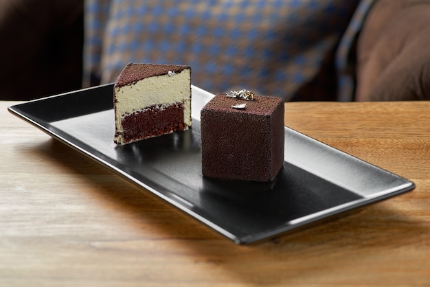 Modern mousse cake covered with chocolate velour. Dessert French cuisine on the table, serving in a restaurant