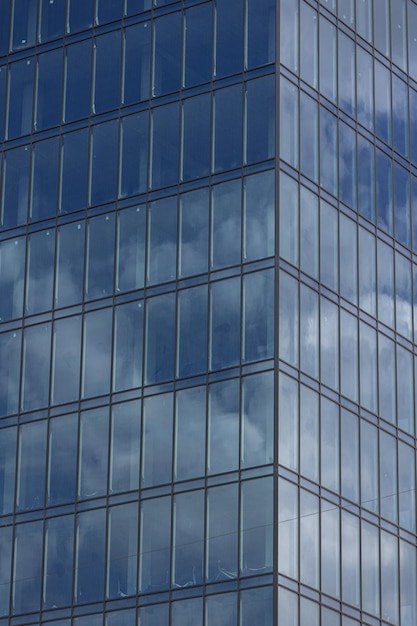 Modern office building with glass facade on a clear sky background Transparent glass wall of office building