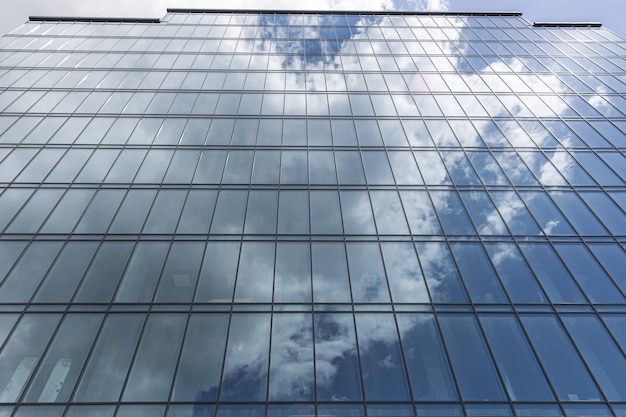 Modern office building with glass facade on a clear sky background Transparent glass wall of office building