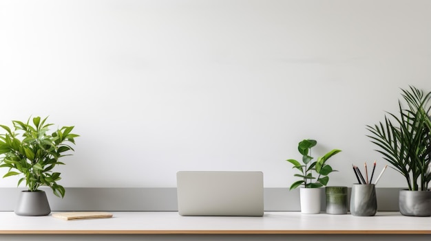 A modern office desk against a clean white wall features neutral grays with green accents from indoor plants