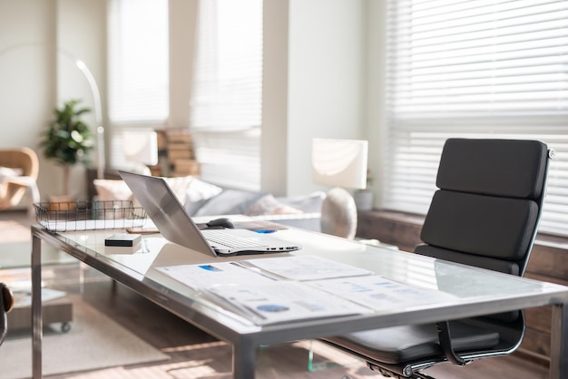 Modern office interior design with office chair and desk in front of windows Workplace with laptop