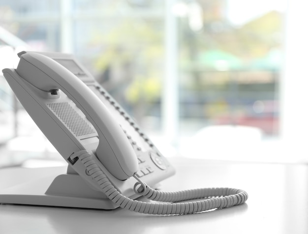 Modern office IP telephone set on light blurred background