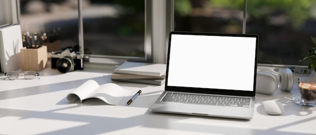 A modern office workspace tabletop against the window with notebook laptop mockup