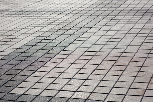 Modern pedestrian road paved with concrete stones. Closeup shot