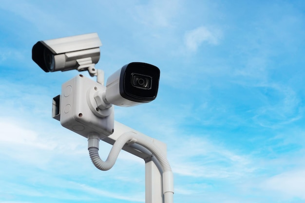 Modern public CCTV camera on pole with the bright sky background