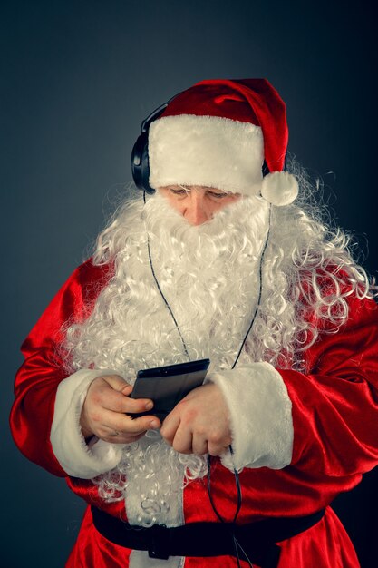 Modern Santa Claus with headphones listening to music