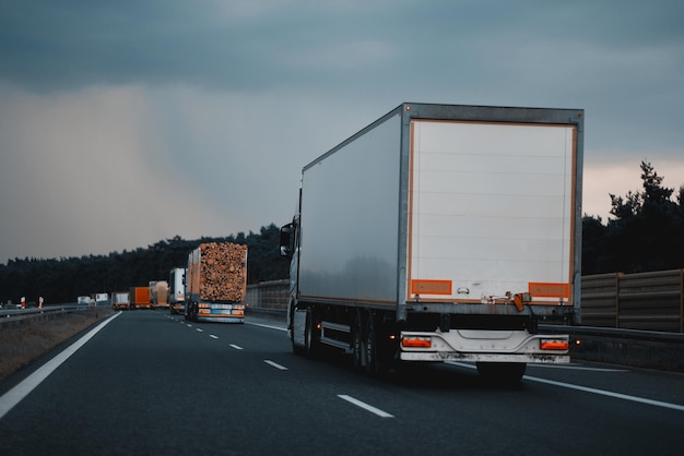 Modern semitrailer trucks on the highway driving in the right lane Commercial vehicle