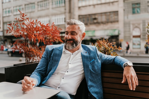 Modern senior businessman smokes a cigarette while resting in a cafe after a hard day39s work