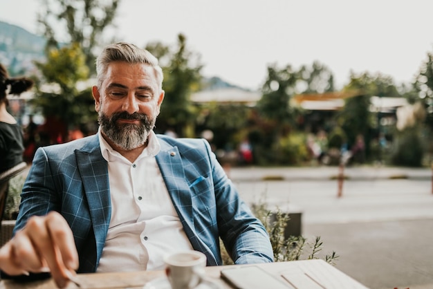 Modern senior businessman smokes a cigarette while resting in a cafe after a hard day39s work