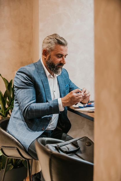 Modern senior businessman smokes a cigarette while resting in a cafe after a hard day39s work