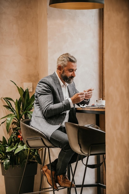 Modern senior businessman smokes a cigarette while resting in a cafe after a hard day39s work