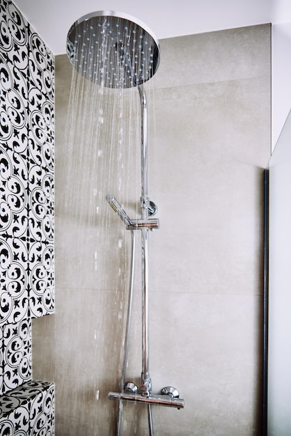 Modern shower with falling water drops in bathroom closeup